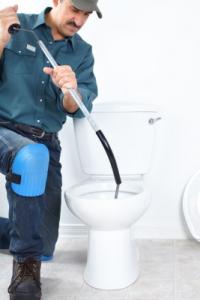 A San Mateo plumbing contractor clears a clogged toilet with a drain snake